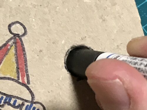 穴に細いペンの先を入れる