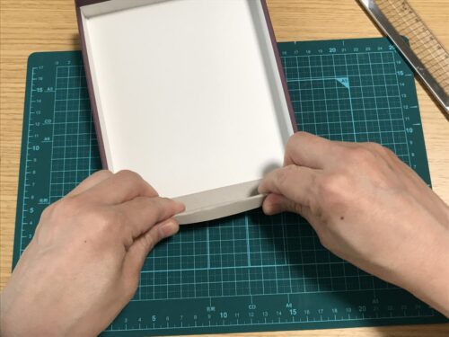 折った厚紙を箱に入れる